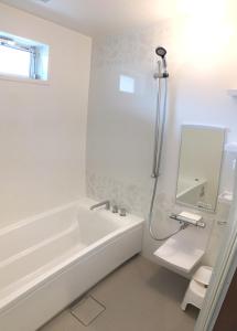 日光B&B Izumi Nikko的白色的浴室设有浴缸和水槽。