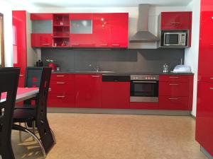 RietzFerienwohnung Familie Meinschad的红色的厨房,配有红色橱柜和桌子