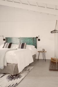 休达德亚Smoix hotel的白色卧室配有一张大床和一张桌子
