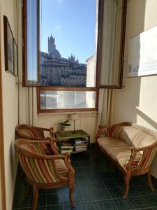 锡耶纳贝尔尼尼酒店的带窗户的客房内配有两把椅子和一张沙发