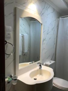 沙迦Al Majarah Residence的一间带水槽、镜子和卫生间的浴室
