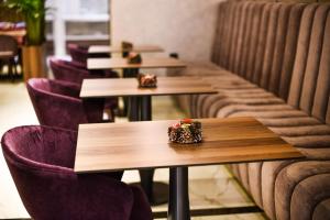 巴尼亚卢卡伊德亚酒店的餐厅里一排桌子和紫色椅子