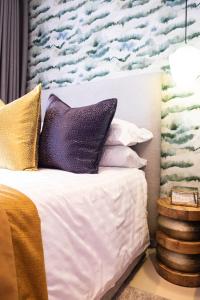 RandjesfonteinThe Wilcrest Apartment的一间卧室配有一张带紫色和金色枕头的床
