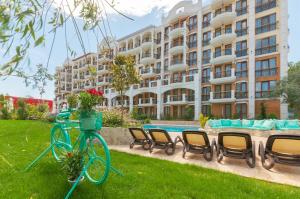 阳光海滩Harmony Suites Grand Resort的停在大楼前的草地上的自行车