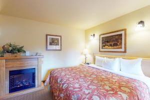 莱文沃思Aspen Suites 506: The Nest的酒店客房配有一张床和一个壁炉。