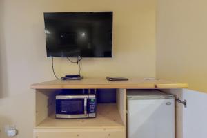 莱文沃思Aspen Suites 506: The Nest的一张带微波炉的桌子和一台墙上的电视