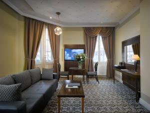 布尔诺格兰迪萨豪华宫殿酒店的客厅配有沙发和桌子