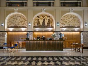 布尔诺格兰迪萨豪华宫殿酒店的饭店的大厅,有女人坐在柜台