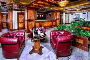 索非亚卡萨博雅纳精品酒店的客厅配有红色皮革椅子和桌子