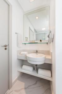 里约热内卢Nobile Hotel Copacabana Design的浴室配有盥洗盆、镜子和毛巾