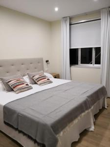 巴尔多维尼奥A Torre do Lago的卧室配有带枕头的白色床和窗户。
