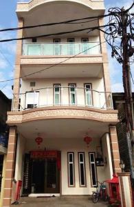 太平Ks Homestay的一座高大的白色建筑,上面设有一个阳台