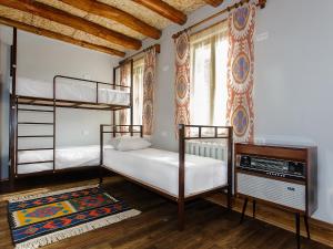 布哈拉Dervish Hostel的一间卧室配有两张双层床和电视