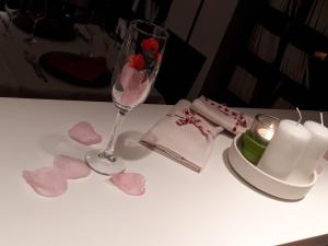 普拉托Wall Art Hotel & Residence的一张桌子,上面放着一杯葡萄酒,还有蜡烛和心灵