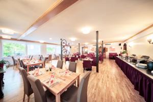 罗森谷地圣雅各布罗森塔尔霍夫兰德酒店的一间带木桌和桌椅的餐厅