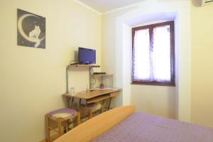格罗日年萨拉旅馆的一间卧室配有书桌、一张床和一台电视。