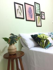 圣阿马鲁Pousada Rio Alegre的一间设有一张床和一张带花瓶的桌子的房间