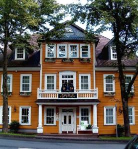 克劳斯塔尔采勒费尔德Harzhotel Zum Prinzen的大型橙色房子,在街上设有阳台