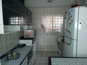 塞拉内格拉Condomínio Vila Paradiso的厨房配有白色冰箱和水槽