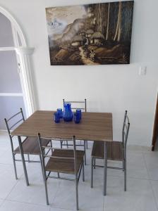 圣玛尔塔Apartamento Ana的餐桌、椅子和墙上的绘画