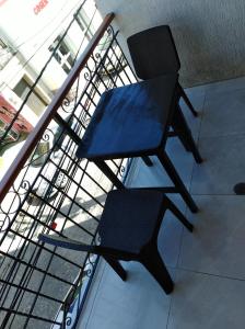 圣玛尔塔Apartamento Ana的一张坐在阳台顶部的黑椅