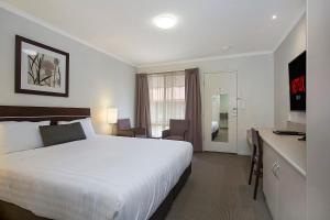 沃纳姆堡榆树汽车旅馆的酒店客房设有一张大床和一张书桌。