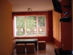 泰特文纳尼维别墅酒店的客厅设有窗户、桌子和凳子