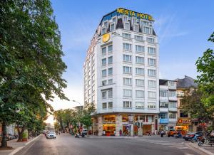 河内Nesta Hotel Hanoi的白色的建筑,上面有标志