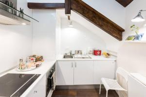 马德里瑞拉托雷斯街公寓的白色的厨房配有白色橱柜和水槽
