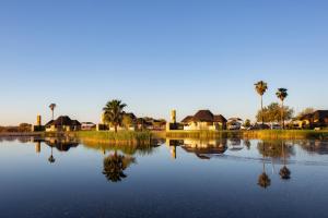 马林塔尔拉帕兰格盖美山林小屋的享有拥有房屋和棕榈树的湖泊美景