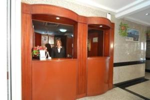 迪拜皇家广场公寓酒店的一位女人站在橙色的门后面