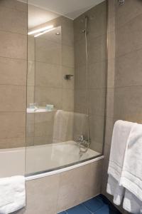 哈卡Hotel Alda Jolio Jaca的浴室配有浴缸、淋浴和毛巾。