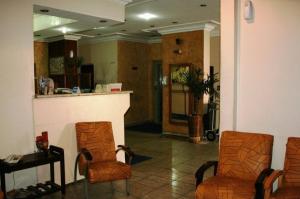 南圣卡埃塔诺坎普里森奥圣卡埃塔诺酒店的大厅设有两把椅子和室内柜台