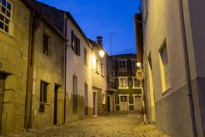 贝尔蒙特Casa dos Poetas的一条空洞的小巷,晚上有建筑物和街道标志