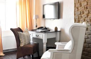 新策勒新策勒修道院酒店的客房设有书桌、椅子和镜子
