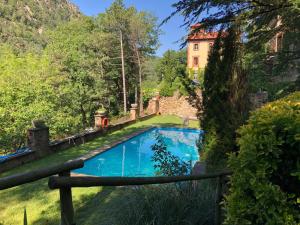 里贝斯的弗里瑟Els Apartaments del bosc的花园内的游泳池,后方是一座房子