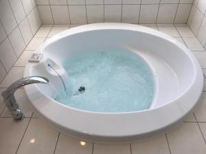 今归仁村シーブリーズ古宇利的浴室设有装满蓝色水的浴缸。