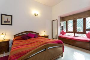 新德里Eleven Bed & Breakfast的一间卧室设有一张大床和两个窗户。