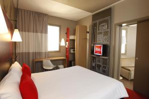 斯法克斯Ibis Sfax的一间酒店客房,配有一张白色的床和一张书桌
