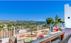 莫莱拉Villa Beniarres Guest House B&B in Moraira的阳台上的木桌和食物