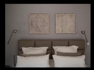 多特蒙德TM Suites的一张带两个枕头的床和墙上的两张照片