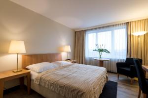 柏林斯图加特瑞拉科萨酒店的配有一张床、一张书桌和一扇窗户的酒店客房