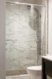 蒙特利尔Auberge du Vieux Port by Gray Collection的浴室设有玻璃淋浴间和卫生间