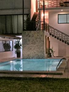 San Juan Bautista TuxtepecHotel Sacre的夜间在房子前面的游泳池