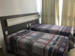 托雷斯Apartamento 601 3 Dormitórios的一间卧室配有两张床和一张铺着地毯的卧室