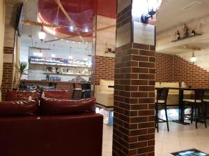 多布里奇蒂阿拉酒店的一间设有红色沙发的餐厅和一间酒吧