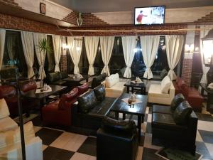 多布里奇蒂阿拉酒店的餐厅配有沙发、桌子和电视。
