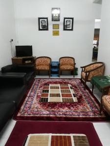 Kampong Pantai HalbanTSA Jitra Homestay的带沙发和地毯的客厅