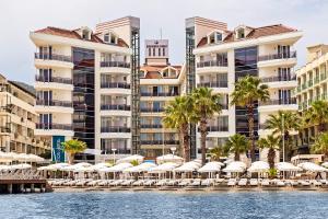 马尔马里斯Poseidon Hotel - Adult Only的享有水景,配有椅子和遮阳伞