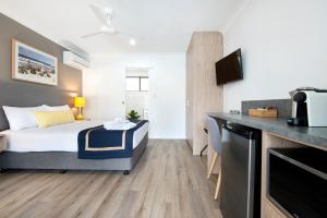 黄金海岸Blue Heron Boutique Motel的酒店客房带一张床和一个厨房